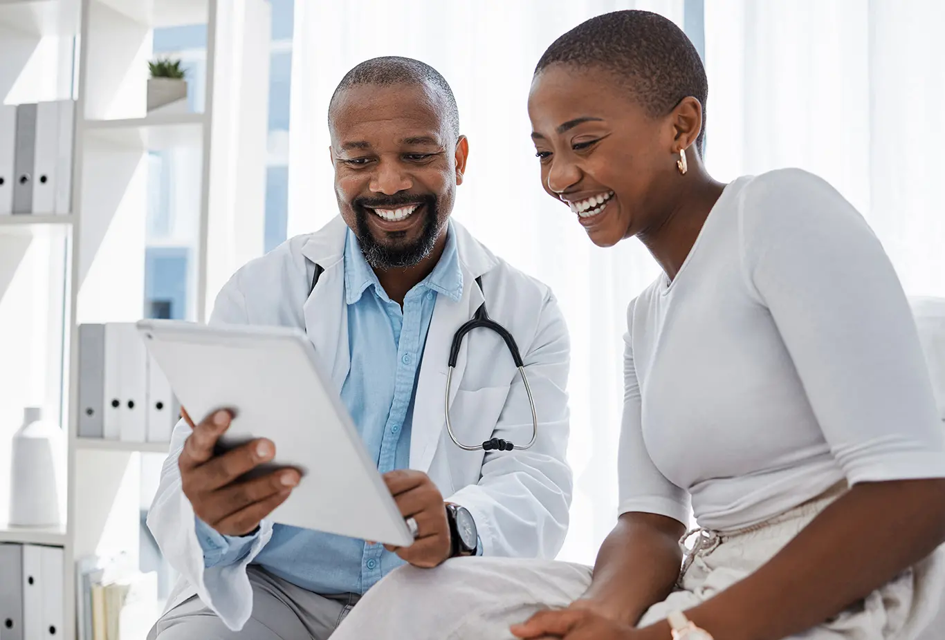 Leerink Partners Healthcare Services-Male doctor with a female patient reviewing results on an ipad